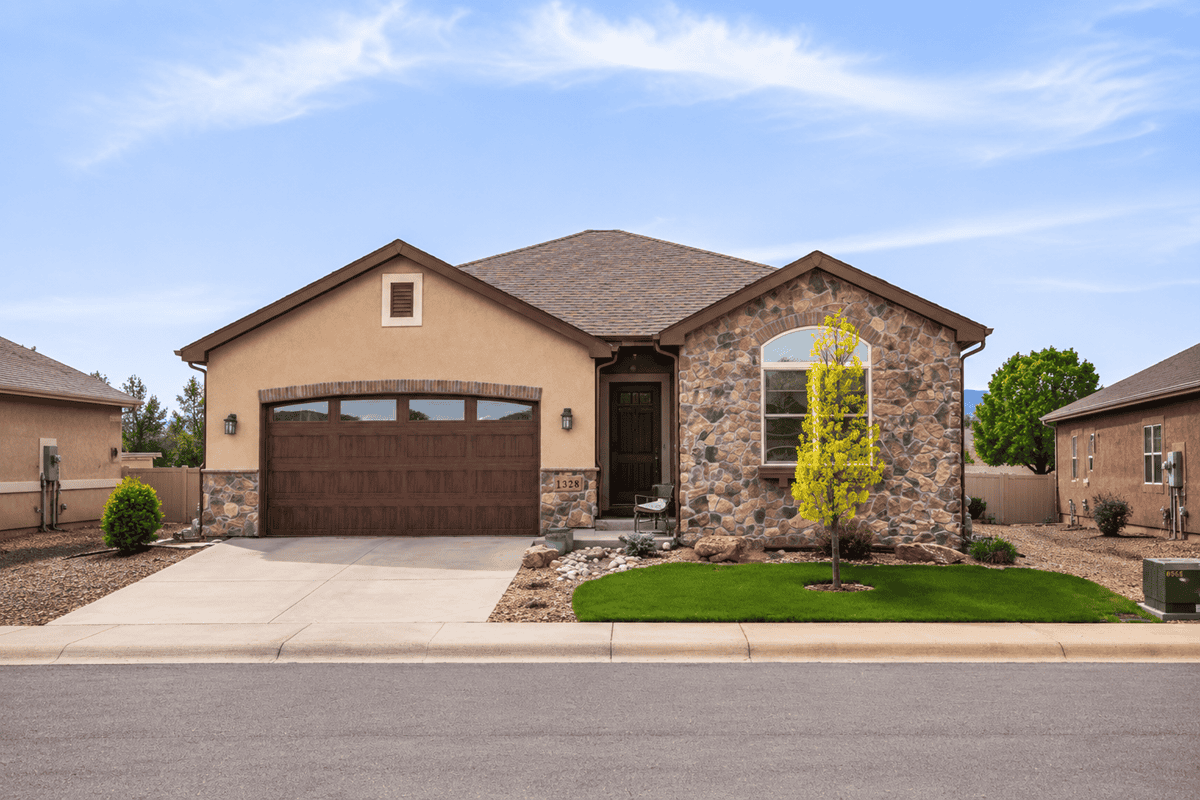 A stucco and stone Ranch elevation with covered front porch and front-entry two-car garage. 2 beds, 1,802 sq ft — Plan #161-1297.