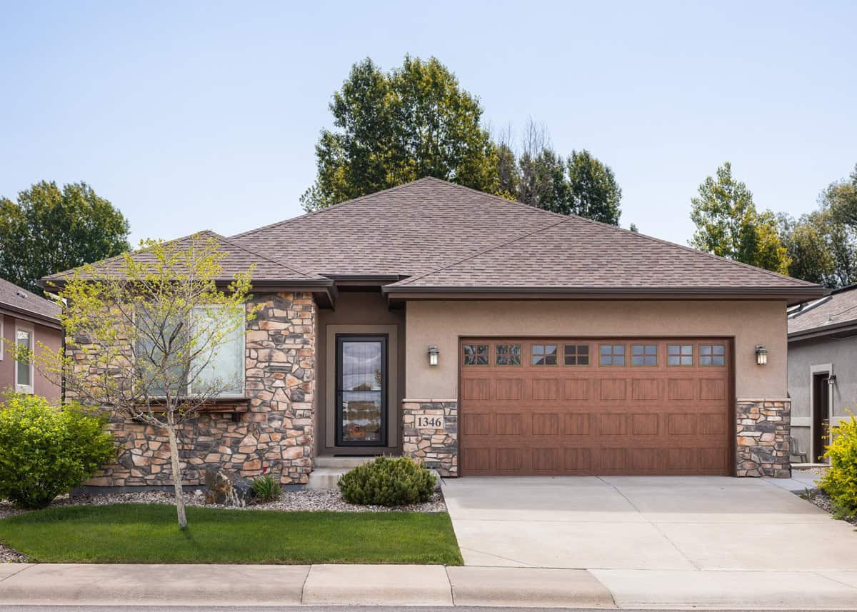 A Southwest-style home with stucco and stone exterior, hip roofline, and covered entry porch. 3 beds, 1,756 sq ft — Plan #161-1298.