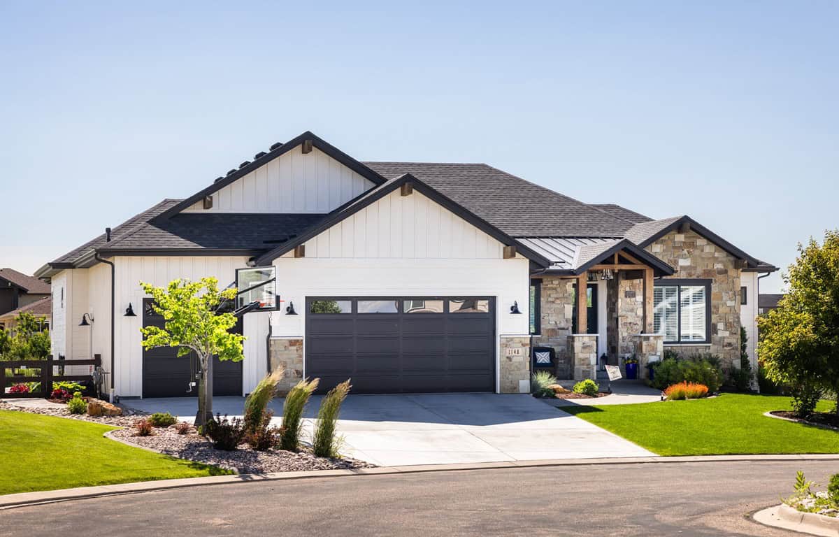 A single-story Ranch home with a covered front porch, stone and board-and-batten exterior, and a mixed gable and hip roofline. 3 beds, 2,662 sq ft - Plan #161-1319.