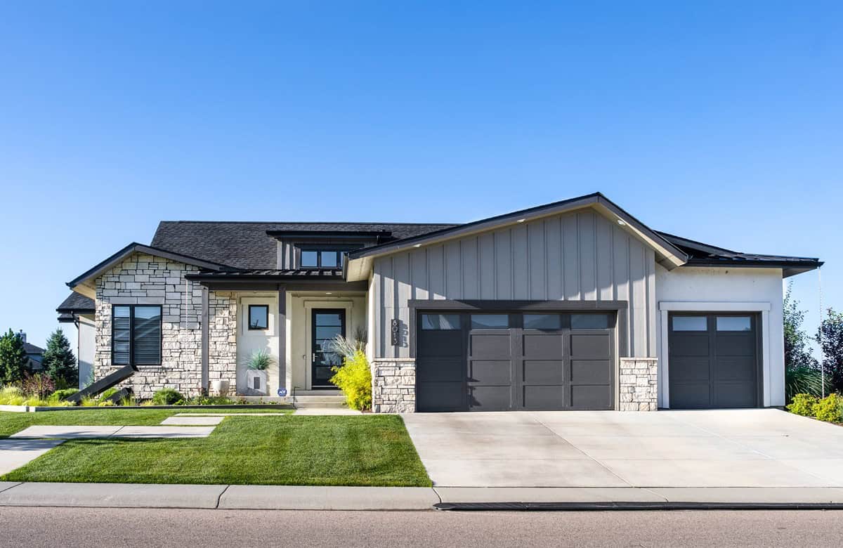 A Contemporary Ranch home with board-and-batten siding, stone accents, covered front porch, and gable roofline. 3 beds, 2,485 sq ft - Plan #161-1325.