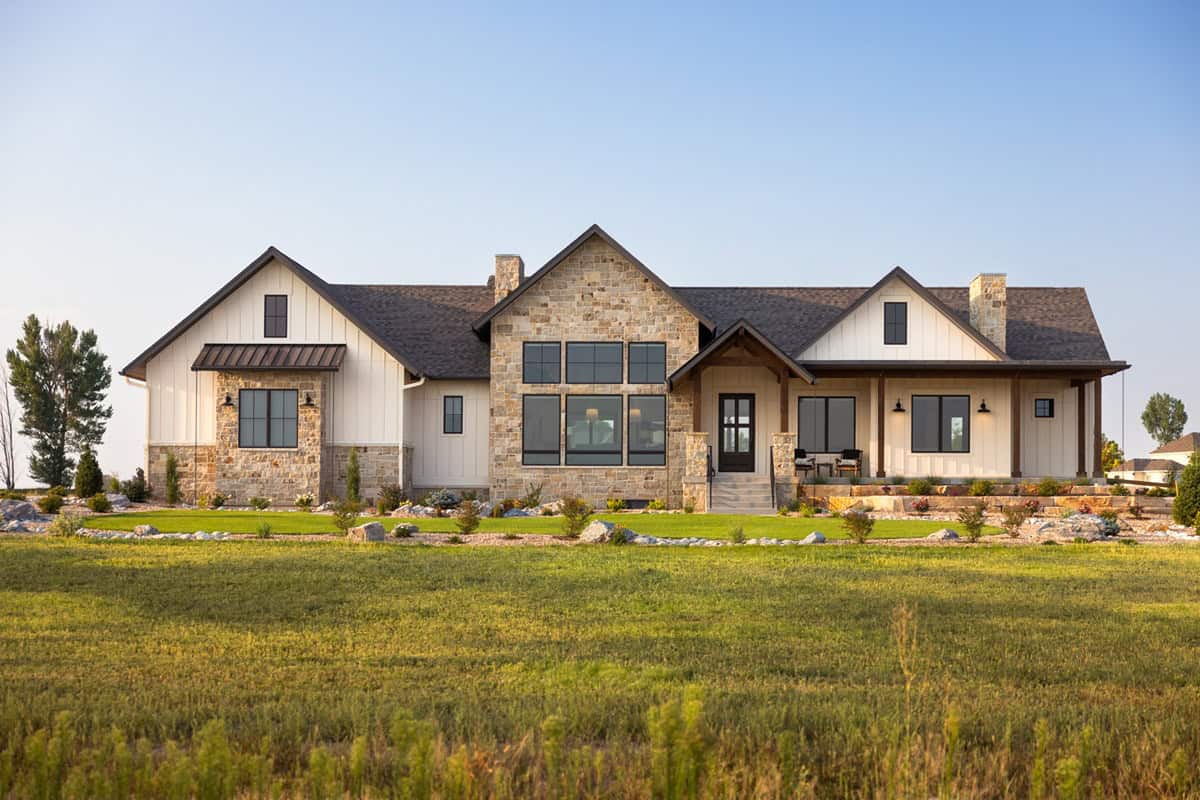 Modern Farmhouse facade with stone and board-and-batten siding, gable roofline, and covered front porch. The side-entry garage occupies 1,084 sq ft, creating exceptional storage and hobby space for a 2-bedroom design. 2 beds, 2,645 sq ft - Plan #161-1326