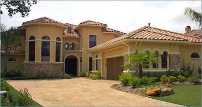 Luxurious Mediterranean style house with arched openings, stucco-and-stone exterior, and red tile roof.