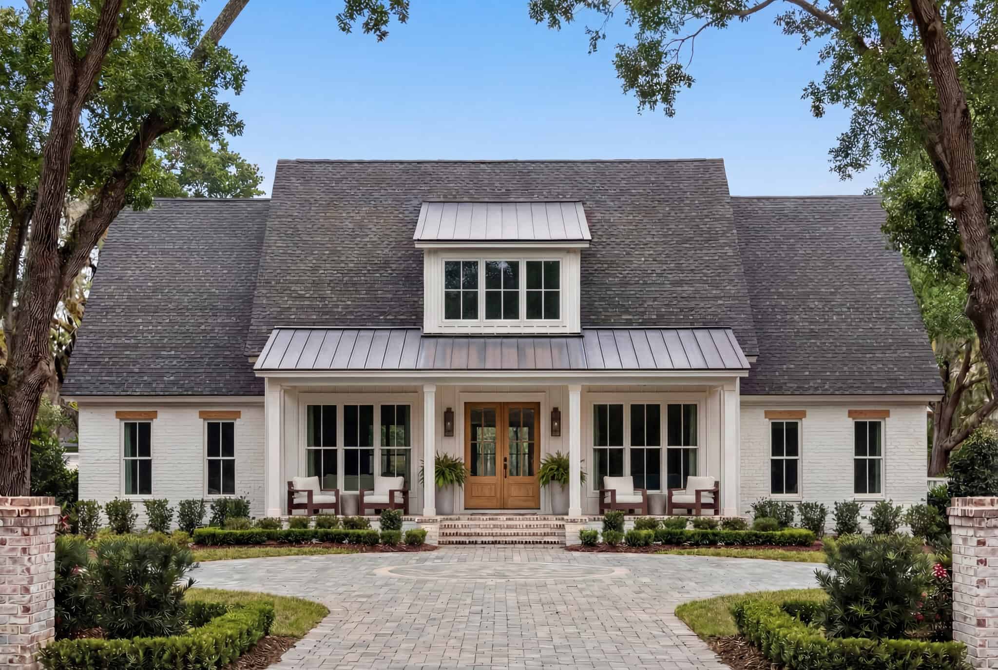 Modern farmhouse with board and batten over brick base, metal accent porch roof, covered front porch, and clean gable roofline — Plan #142-1507
