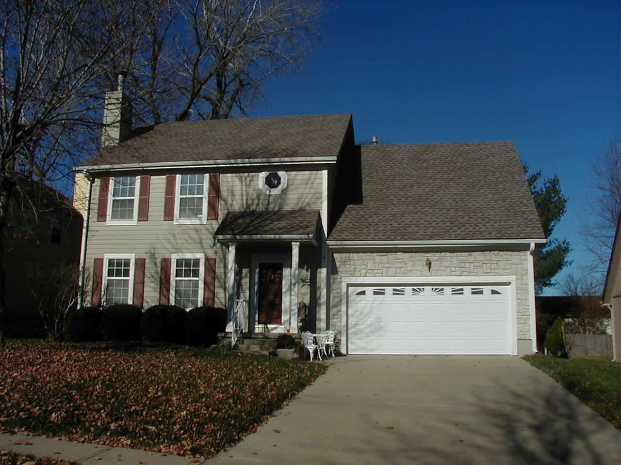 Two-story Traditional home exterior with stone veneer base, lap siding, columned entry porch, and front-entry garage, Plan #147-1167.