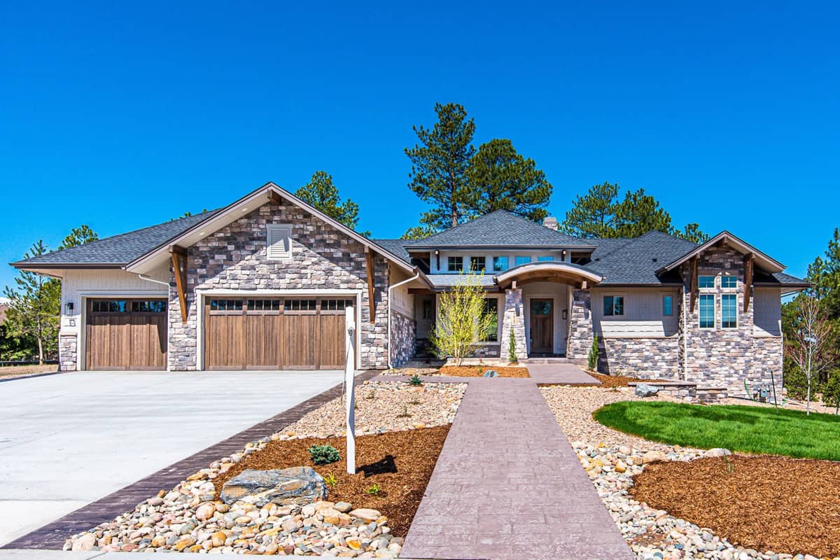 Craftsman home exterior with stone and shake siding, gabled rooflines, covered entry porch, and three-car garage, Plan 161-1306