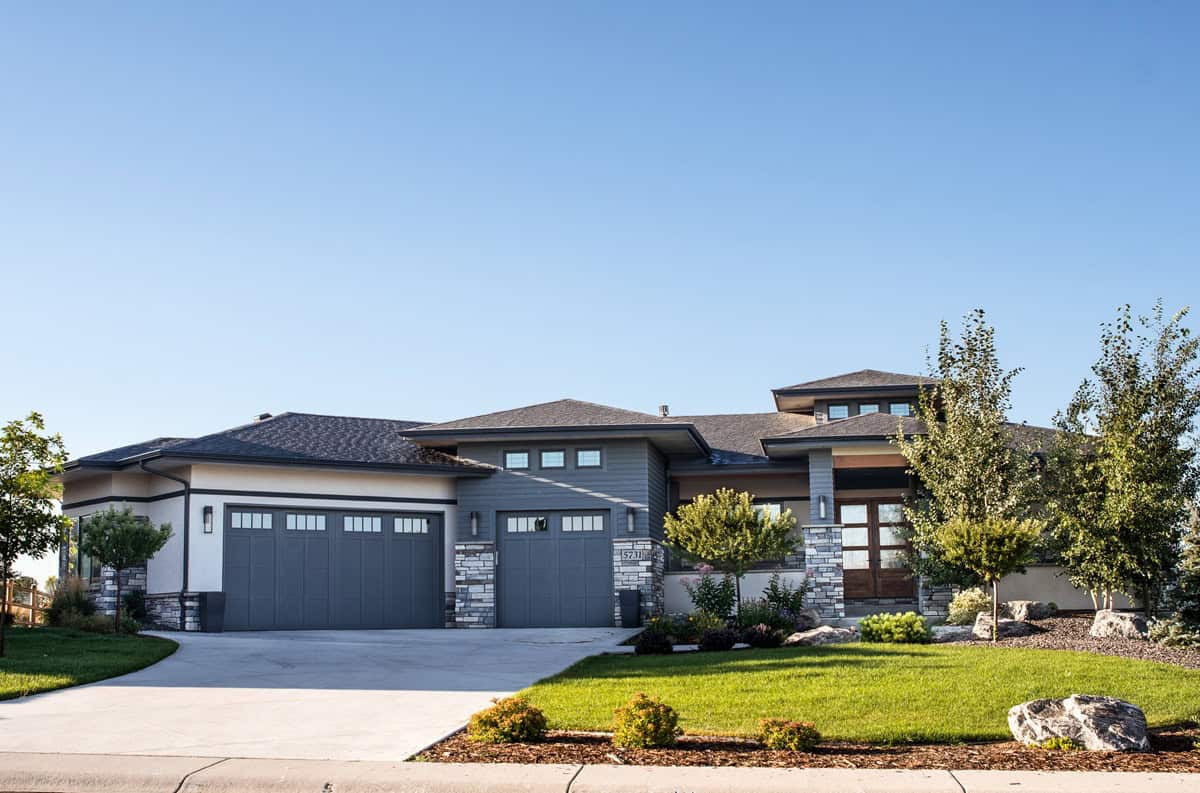 Front elevation of single-story Prairie ranch with low hip roof, stucco and stone exterior, covered porch, Plan 161-1318