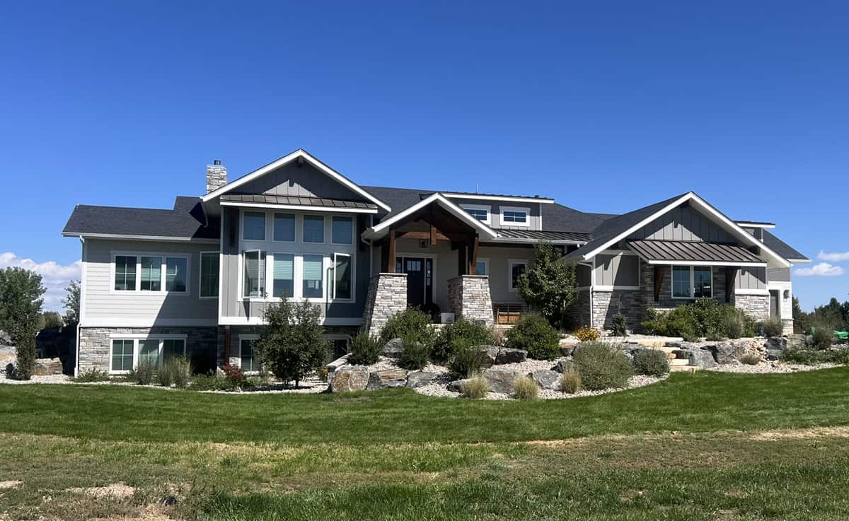 Craftsman ranch facade with gable roof, mixed materials of rock and lap siding, covered front porch, and side-entry 4-car garage. 2 beds, 2.5 baths, 2,513 sq ft - Plan #161-1330