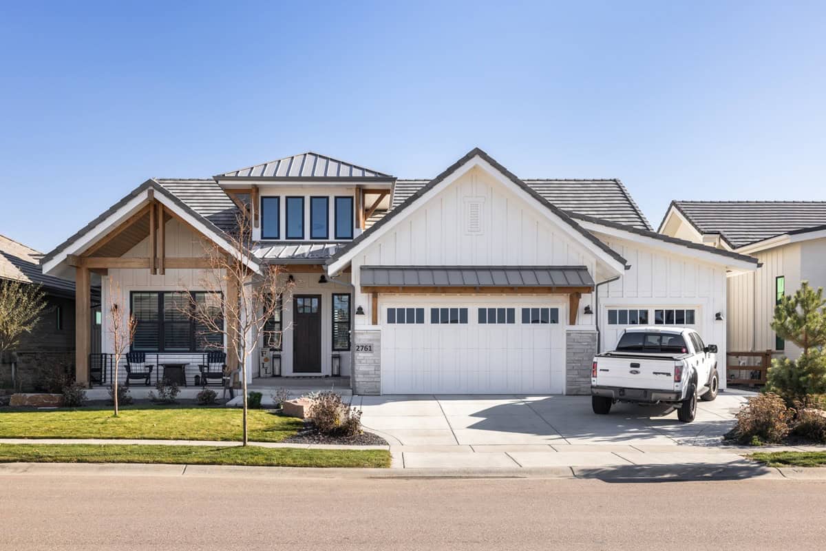 A modern farmhouse elevation with board and batten siding, stone accents, and a front-entry 3-car garage. 3 beds, 2.5 baths, 2,516 sq ft - Plan #161-1332
