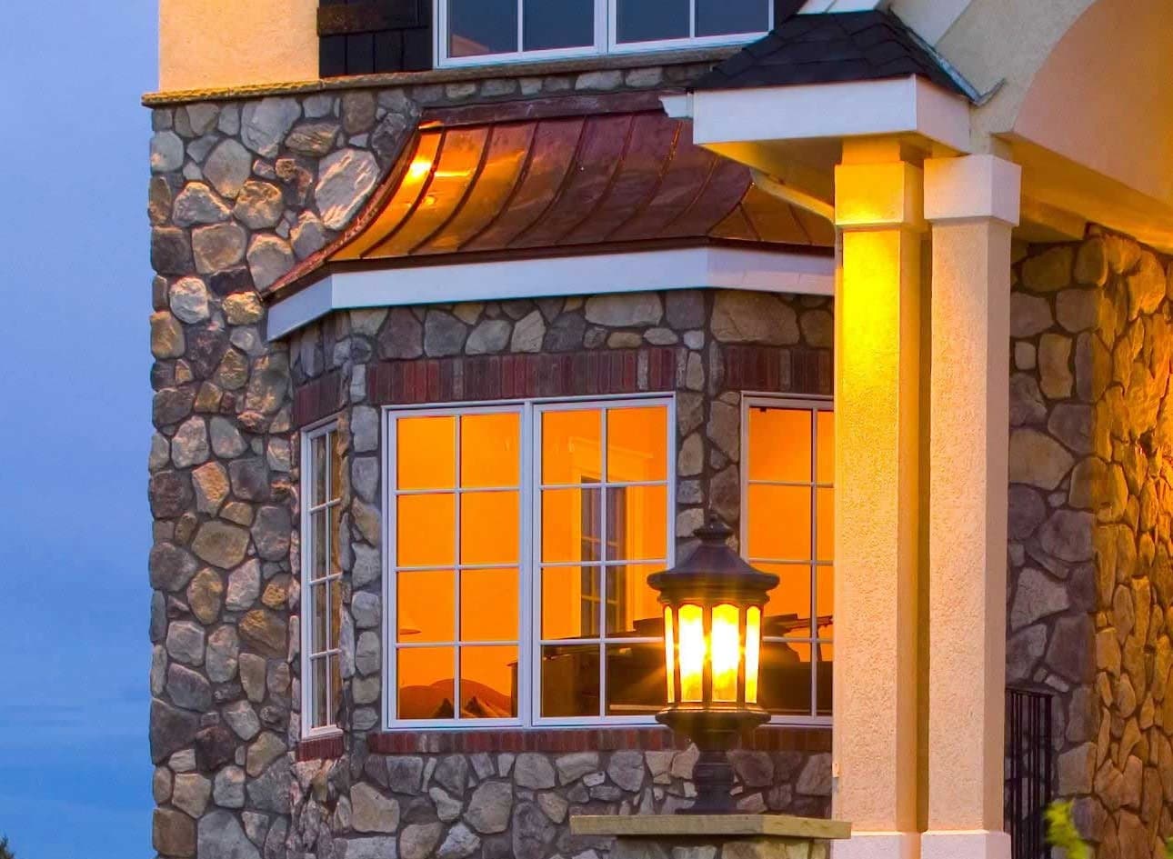 A bay window projects from the stone exterior of this home.