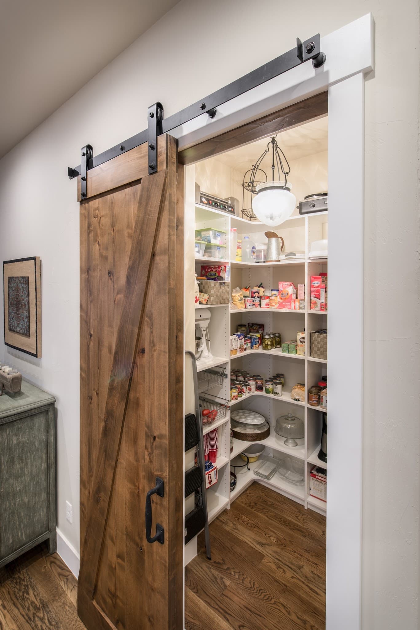 A sliding barn-style door closes the pantry without using swing space.