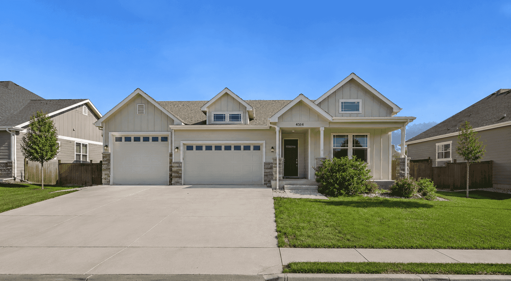 Craftsman Ranch facade with covered front porch, stone accents, and a four-bay garage wing. 3 beds, 1,654 sq ft — Plan #161-1289.