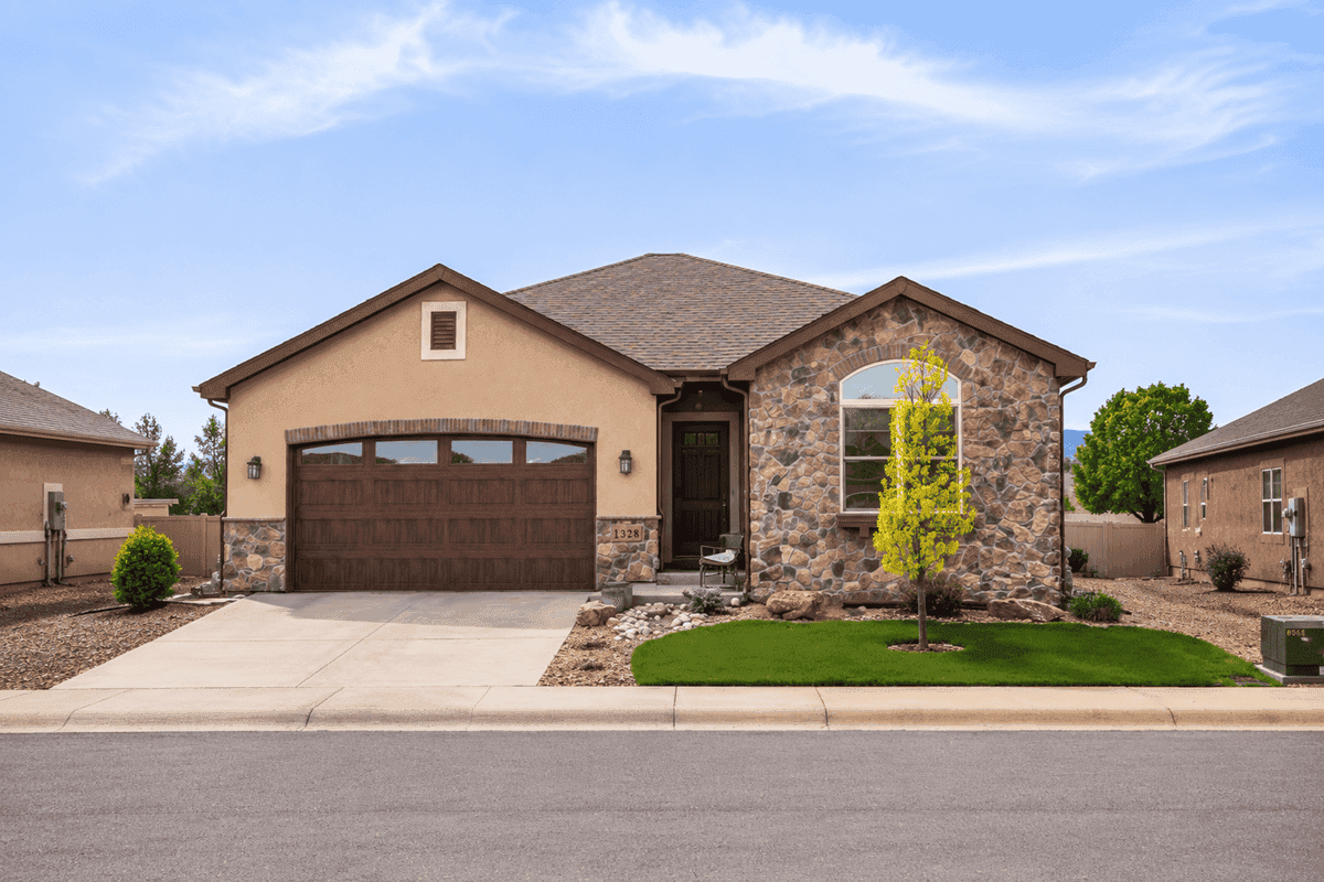 A stucco and stone Ranch elevation with covered front porch and front-entry two-car garage. 2 beds, 1,802 sq ft — Plan #161-1297.