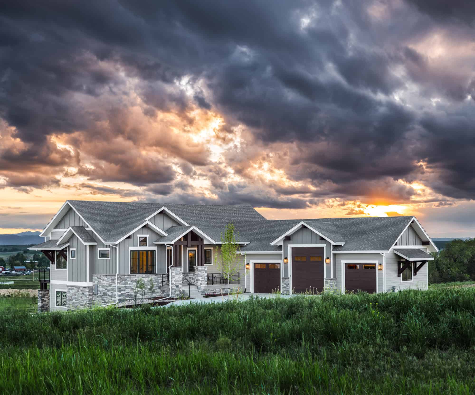 Craftsman ranch elevation with stone accents, board and batten siding, and a covered front porch. 3 beds, 2,085 sq ft - Plan #161-1312.