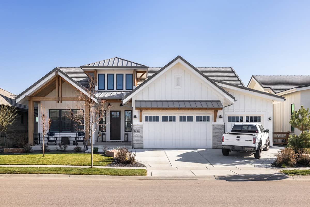 A modern farmhouse elevation with board and batten siding, stone accents, and a front-entry 3-car garage. 3 beds, 2.5 baths, 2,516 sq ft - Plan #161-1332