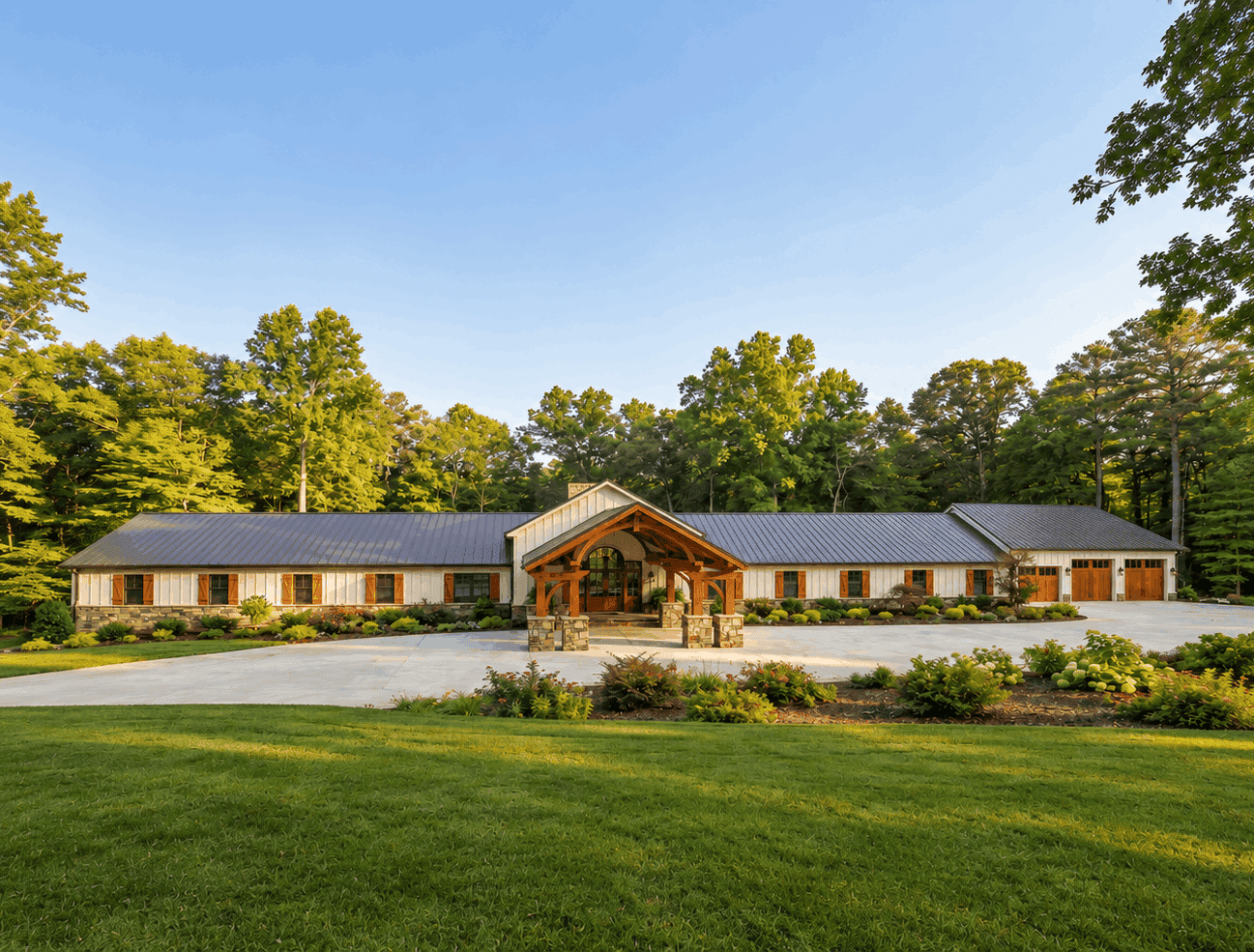 A Luxury Barndominium elevation with board and batten siding, cut stone accents, metal gable roof, and screened porch. 9 beds, 10.5 baths, 7,495 sq ft - Plan #221-1019
