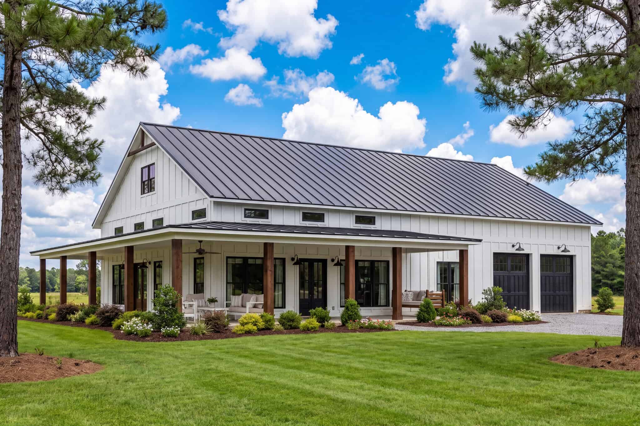 Barndominium elevation with wraparound porch, board-and-batten siding, metal gable roof, and oversized front-entry garage. 3 beds, 2,000 sq ft — Plan #142-1470.