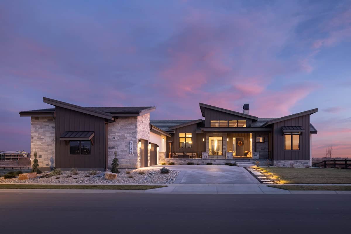 Modern home with courtyard entry, stucco and stone facade, and multi-gable roofline. 2 beds, 3,037 sq ft - Plan #161-1322