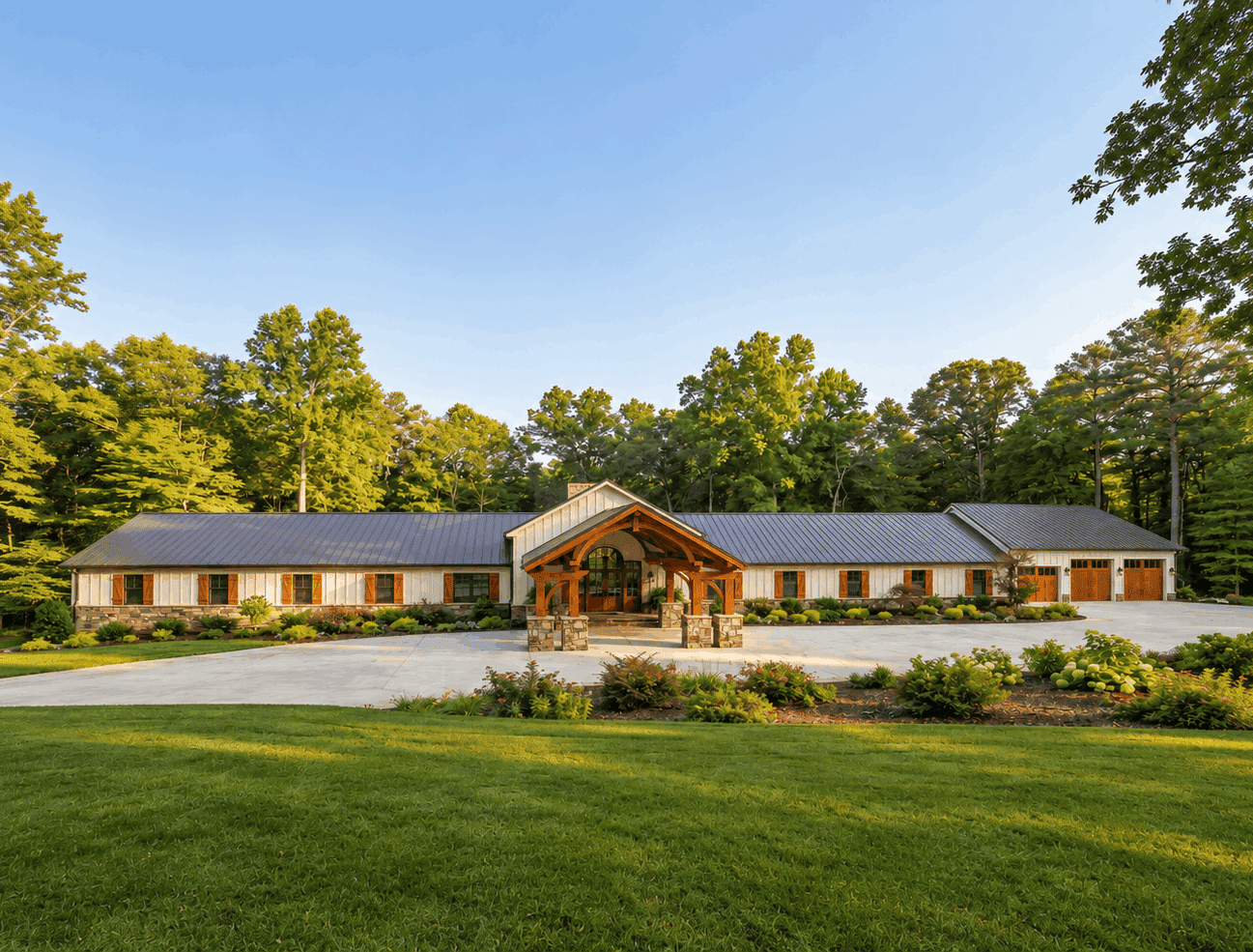 A Luxury Barndominium elevation with board and batten siding, cut stone accents, metal gable roof, and screened porch. 9 beds, 10.5 baths, 7,495 sq ft - Plan #221-1019